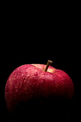wet red delicious apple close-up on black background