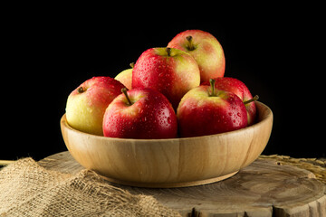 Close up Apples in a wooden bowl on black background