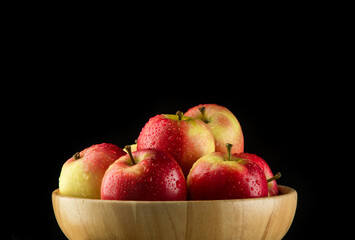 Close up Apples in a wooden bowl on black background