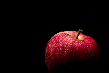 wet red delicious apple close-up on black background
