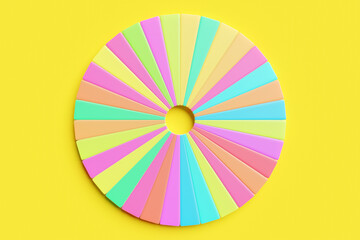 3d illustration of a multicolored circle divided into a large number of sectors on a yellow isolated background. Round chart