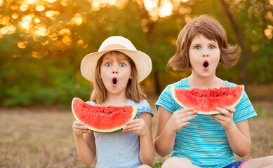 Adorable child girls with wonder face and with watermelon in hands think about question, thoughtful about confusing idea. Summer holidays