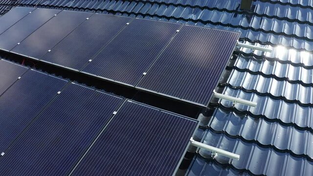 Solar panel installation on private home - Closeup rotating aerial with details of panels showing - Rotating ascending aerial with solar flare on roof