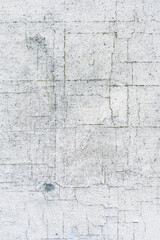 Old wall with visible perpendicular cracks, dirty and damaged by the weather