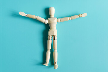 The figure of a wooden man in close-up on a colored background. Figure of a wooden man on a light background of kopi space