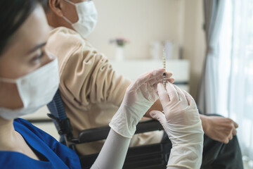 Caucasian nurse wear mask hold vaccine syringe for Senior disabled man