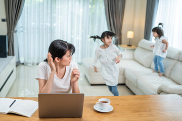 Frustrated busy Business mother work at home with children play around