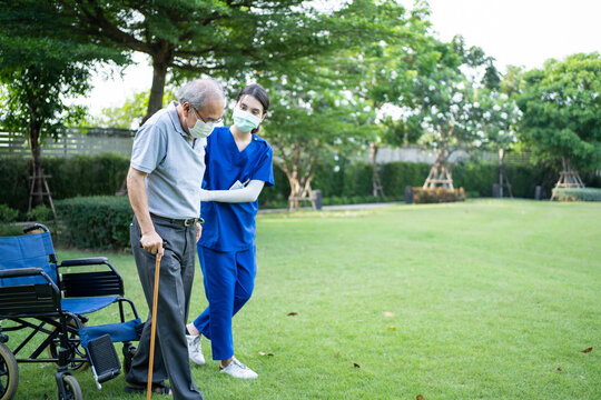 Carer Nurse Wear Mask Support Disabled Senior Elderly Man Walk In Park	