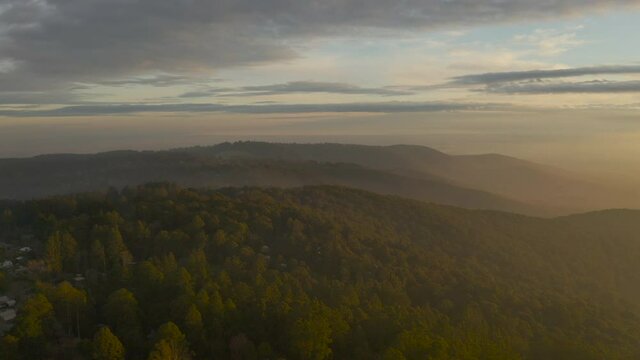 Slow parallel aerial perspective looking across beautiful natural landscape above Olinda, Victoria, Australia.