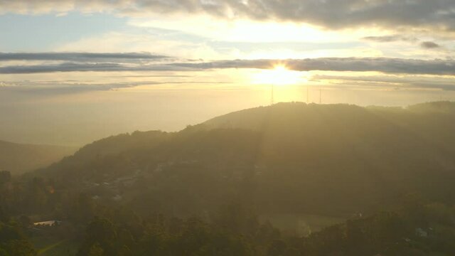 Slow descent aerial perspective looking toward television towers ontop of Mount Dandenong, Victoria, Australia.