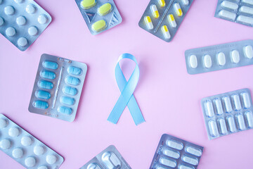 Blue ribbon symbol of prostate cancer with many pills and drugs clusters on bright background....