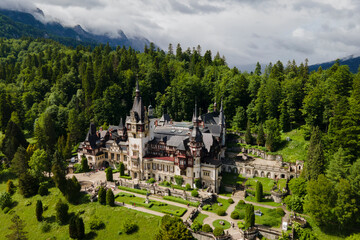 Fototapeta premium Aerial drone view of Romanian Pelesh castle, royal residence and museumin sun and fog