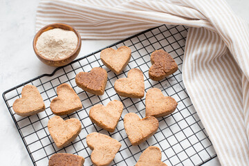 homemade heart-shaped cookies cool on the grill, valentine's day gift with love, gluten-free buckwheat flour pastries.