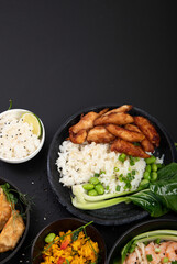 Assorted asian dishes and snacks on black background. Traditional food concept.
