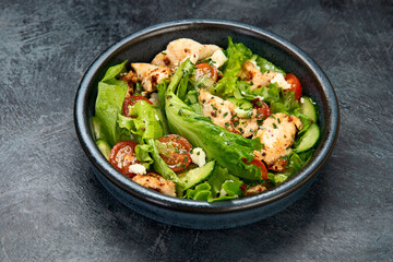 Fresh chicken salad on drak gray background. Healthy food concept.