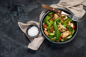 Fresh chicken salad on drak gray background. Healthy food concept.