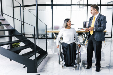 latin disabled transgender businesswoman talking business with colleague at office in Mexico City, in disability concept and disabled people