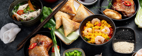 Assorted Chinese dishes and snacks on dark gray background. Traditional food concept.