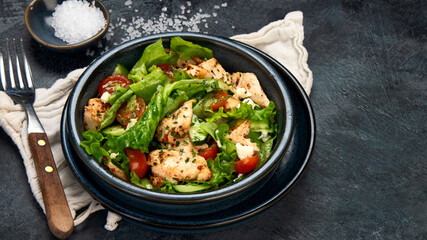 Fresh chicken salad on drak gray background. Healthy food concept.
