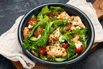 Fresh chicken salad on drak gray background. Healthy food concept.