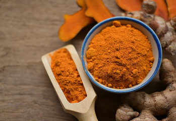 turmeric and turmaric powder on wooden background.