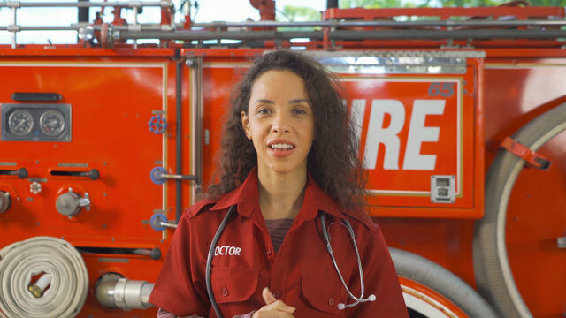 A portrait of caucasian first Aid doctor woman with uniform talking to colleagues in webcam group video call conference online, An emergency accident rescue. People. Hero with fire truck car. Service