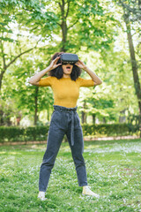 Afro woman wearing a virtual reality glasses in a garden.