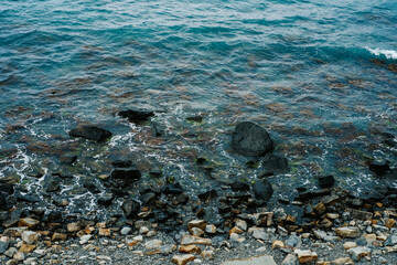 beautiful background texture of the coastline of the sea or lake. rocky coast and ocean waves, top view 