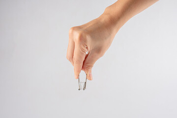 Hand and paperclip on white background.
