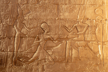 Engraved egyptian figures on the ancient wall