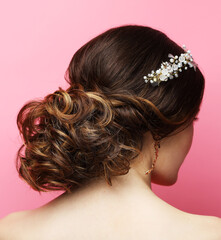 Bride with wedding diadem. Young fashion model with Beautiful Hairstyle over pink background.