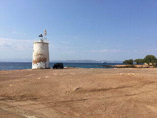 Fototapeta na wymiar The Lighthouse of Aegina (Faros Mbouza) on the coastal road on the island of Aegina, Greece.