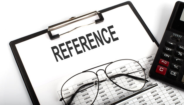 REFERENCE text on the paper fold with calculator, glassesand pen