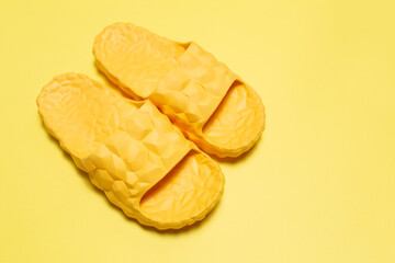 Close-up of yellow slippers on yellow background.