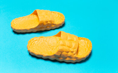 Close-up of yellow slippers on background of blue color.