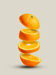 Orange slices flying in the air isolated on pastel beige background. Juicy and fresh summer citrus...