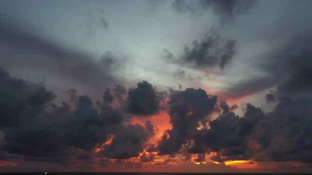 aerial view The rain clouds floated over the evening sea, .the red sun shining in the background.amazing light of nature cloudscape sky .in sunset Nature video and travel concept..