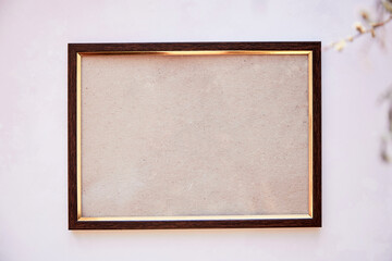 Brown frame mockup on vintage surface. Vintage frame with dry Lagurus ovatus grass and gipsophila. Beige bakground, Scandinavian interior. High quality photo