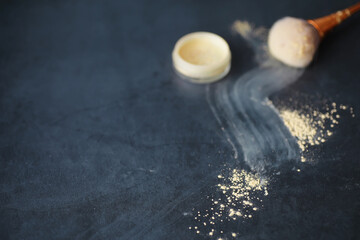 Powder and makeup brush. Brown powder on the background. Makeup products. Style concept.