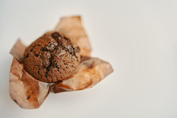 Chocolate muffin close up. Delicious dessert. Cupcake with dark chocolate in paper wrapper. Copy space for advertising and marketing.