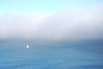 A sailboat cruising in the sea with fog, San Francisco, US