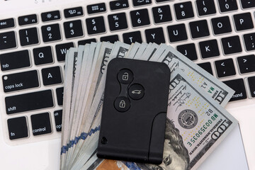 Obraz premium sale online purchase concept car keys with dollar banknotes over laptop keyboard