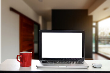 Fototapeta premium Front view of cup and laptop, smartphone, and tablet on table in office