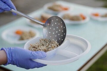 Close up of volunteers scooping the food to share with the needy
