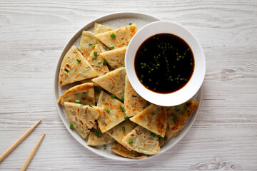 Homemade Scallion Pancakes with Soy Dipping Sauce on a white wooden background, top view. Flat lay, overhead, from above.