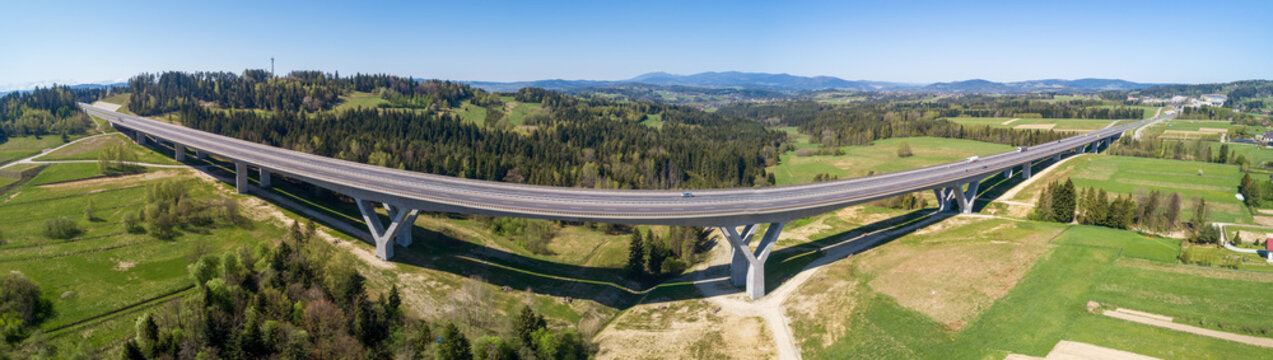 Wide aerial panorama of a new highway on national road no 7, E77, called Zakopianka, near Skomielna Biala village. Far view of Babia Gora mountain in the background