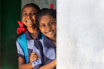 portrait of a rural school girls smiling and standing in school