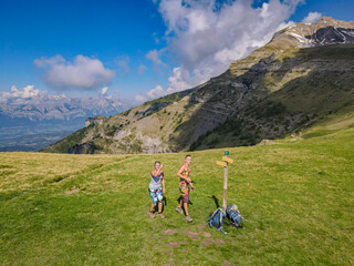 Fototapeta na wymiar Aerial view of a hiking couple enjoying the epic view in the mountains of the Alps