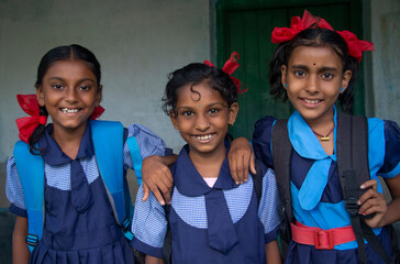 Smiling Three indian Rural School Girl wearing School Uniform Standing in school - obrazy, fototapety, plakaty