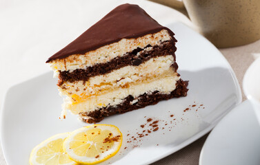 Sweet dessert. Serving of light chocolate lemon cake on white plate..